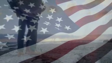 Bir Amerikan çifti bir plajda gün batımı ve rüzgar karşı sallayarak bir Amerikan bayrağı izlerken dijital kompozit