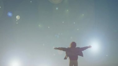 Kollarını sonuna kadar açık denize bakan bir kadının arka görünümü