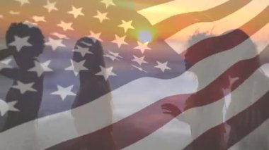 Gün batımı ve bir Amerikan bayrağı arka planda sallayarak plajda dans gençler bir grup dijital kompozit