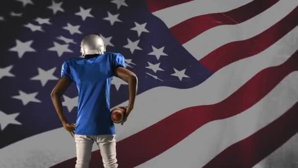 背景に手を振るアメリカの旗でハイプアップアフリカ系アメリカ人サッカー選手の背面図 — ストック動画