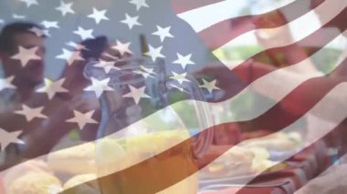 Arka planda sallayarak bir Amerikan bayrağı ile bir piknik sahip arkadaşlarınızla mutlu bir ailenin dijital kompozit