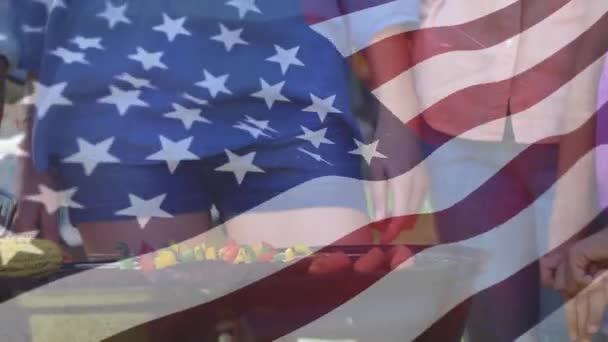 数字复合的人烧烤和一面美国国旗在前景挥舞 — 图库视频影像