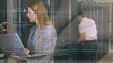 Orta yaşlı beyaz bir kadın ve erkek teknisyenlerin yan görünümü ve arka görünümü, sırasıyla, iş kıyafetleri içinde bir sunucu kulesinde siber güvenlik kontrolü yapıyor. Arka planda animasyon yazarak rasgele kodları ve komut dosyalarını taşıma