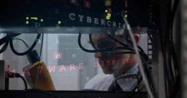 Bir bilgisayar ekranından siber suç uyarısı ile bir veri sunucusu rafa aniden gülümsedi dijital kablo analizör tutan genç bir erkek Kafkas teknisyeninin yakından görünümü. 4k