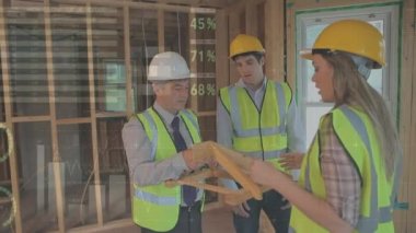 Ön planda grafikler ve istatistikler ile şantiye içinde bina için yapı tasarımı tartışan mimarların dijital kompozit