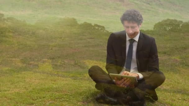 Digital Composite Caucasian Businessman Typing His Tablet While Sitting Grass — Stock Video