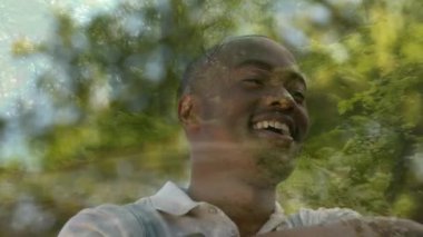 Ağaçların arka plan ve ön planda bir orman gerginlik bir görünüm ile gülümseyen bir Afrikalı Amerikalı adam dijital kompozit