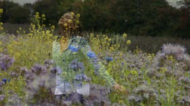 Çiçeklerle dolu bir ön plan ile çiçek bir alanda gaily dönen beyaz bir kadının dijital kompozit