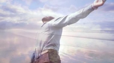 Bir plaj arka plan üzerinde kollarını geniş açık bir adamın dijital kompozit