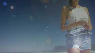 Bokeh ışık efektleri ile sahilde mesajlaşma kafkas bir kadının ön görünümü