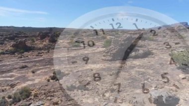 Az bitki örtüsü ile kayalık bir ova dijital kompozit. Analog saat ön planda çalışıyor