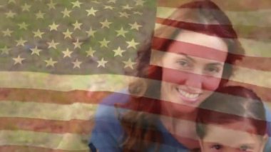 Ön planda sallanan bir Amerikan bayrağı ile parkta eşi ve iki çocuğu ile bir Amerikan askeridijital kompozit