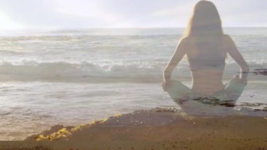 Ön planda dalgalar ile sahilde meditasyon bir kadının dijital kompozit