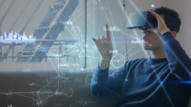 一个白种人坐在沙发上 戴着虚拟现实耳机的数字合成 在前景中飞行着图形和线条 — 图库视频影像
