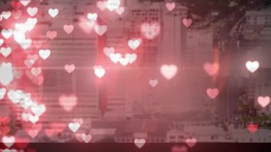 Ön planda uçan kalplerle dolu bir şehrin dijital animasyonu