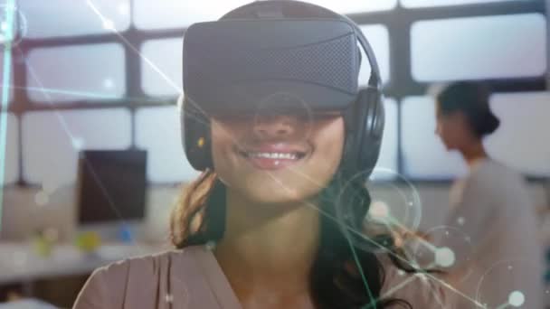 一个白种妇女打字的数字合成 在办公室佩戴虚拟现实耳机 在前台连接线和点 — 图库视频影像