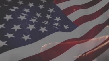 Ön planda sallanan bir Amerikan bayrağı ve kıvılcım dijital kompozit