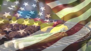 Ön planda sallayarak bir Amerikan bayrağı ile bir aile pikniği üzerinde ızgara et ve sebze Dijital kompozit