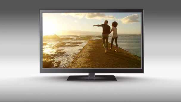 平面电视的数字动画 屏幕上有一对情侣在日落时出现在海滩上 — 图库视频影像