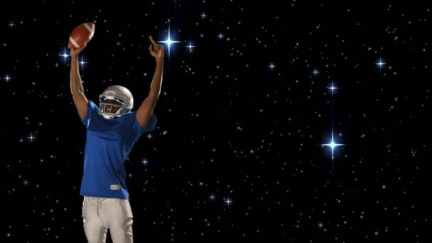 一个非裔美国足球运动员拿着足球 同时举起手臂和星系背景与星星的数字复合 — 图库视频影像