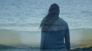 Ön planda okyanus suyu bir görüntü ile ellerini kaldırırken denize bakan bir dağın tepesinde duran bir kadının dijital kompozit