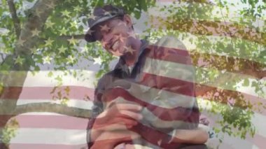 Oğluna sarılan amerikalı bir askerin dijital bileşimi, ön planda sallanan bir Amerikan bayrağıyla onu heyecanla havaya kaldırır.