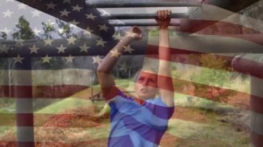 Ön planda sallanan bir Amerikan bayrağı ile maymun barlar üzerinde çalışan bir kadın ordu asker dijital kompozit