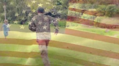 Ön planda sallanan bir Amerikan bayrağı ile sıcak sarılmalar veren bir Amerikan askeri ve oğlunun birbirlerine doğru çalışan dijital kompozit