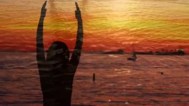 Gün batımında bir liman yakınında yoga yapan bir kadının siluetdijital kompozit