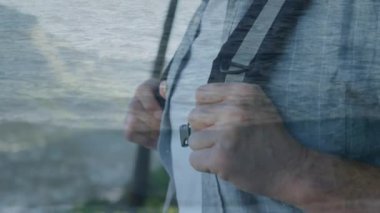Arka plan gün batımı sırasında plaj gösterir iken ufukta görünümlü bir sırt çantası giyen eski bir Kafkas adam dijital kompozit