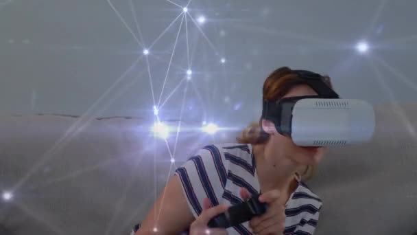 一个白种妇女戴着虚拟护目镜的数字复合 同时播放和发光的不对称线在屏幕上移动 — 图库视频影像