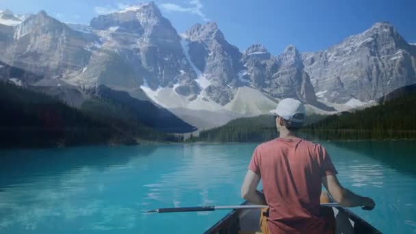 一个白种人坐在一个湖的船上 背景是岩石山的数字动画 — 图库视频影像