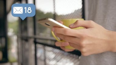 Evde bir fincan kahve ve artan sayılarla bir mesaj balonu simgesi tutarken bir kadının dijital kompozit