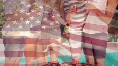 Havuz kenarında içki içerken bir grup farklı arkadaşın dijital kompoziti, 4 Temmuz'da arka planda amerikan bayrağı dalgadalga gelirken.