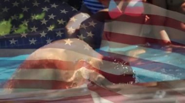 Bir havuzda eğlenen bir grup farklı arkadaşın dijital bileşimi ve bir adamın kafasını sudan kaldırması, 4 Temmuz'da arka planda amerikan bayrağı dalgalanması.