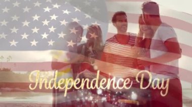 4 Temmuz için altın bağımsızlık günü metniarkasında Amerikan bayrağı dalgalar ise gün batımı nda içecekler üzerinde plajda kutlayan çeşitli arkadaş grubu dijital kompozit.