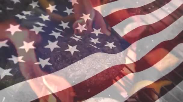 7月4日の背景にアメリカ国旗が波を立てながら 火のグリルでバーベキューに肉のデジタル複合材料 — ストック動画