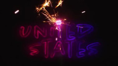 4 Temmuz için karanlık arka planda ışıklı bir ışıltı yanıp sönerken kırmızı ve mavi degradeli bir ABD metninin dijital animasyonu.