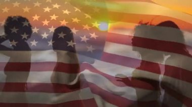 4 Temmuz için arka planda bir Amerikan bayrağı dalgalar ise gün batımı sırasında plajda dans çeşitli kadınların bir grup siluet dijital kompozit.