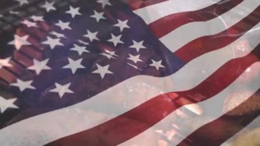Sosisli sandviç ve et 4 Temmuz için arka planda bir yangın ızgara üzerinde pişirilirken Amerikan bayrağı sallayarak Dijital kompozit.