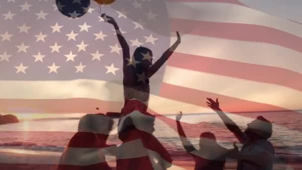 국기가 배경으로 파도를 일으키면서 풍선과 해변에서 축하하는 다양한 친구들의 실루엣의 — 비디오