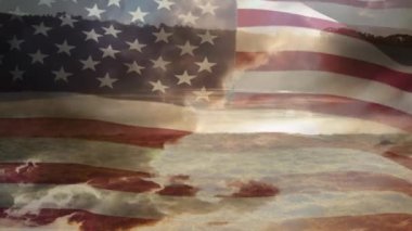Gün batımında bulutlarla gökyüzünün arka planı yla sallanan Amerikan bayrağının dijital animasyonu.