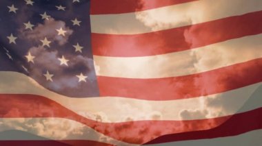 Gün batımında bulutlarla gökyüzünün arka planı yla sallanan Amerikan bayrağının dijital animasyonu.
