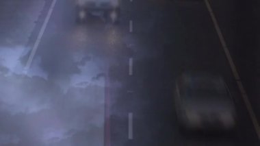 Yoğun bir yol ve yıldırım yanıp söner ile bir hikaye gece gökyüzü dijital kompozit. Araçlar hızlı hareket ediyor.
