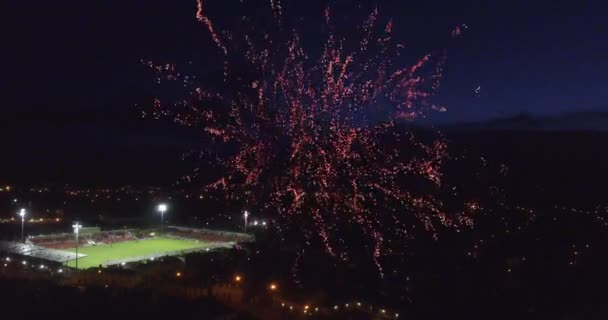 Işıklı Stadyum Ile Bir Şehrin Üzerinde Karanlık Gökyüzünde Patlayan Kırmızı — Stok video