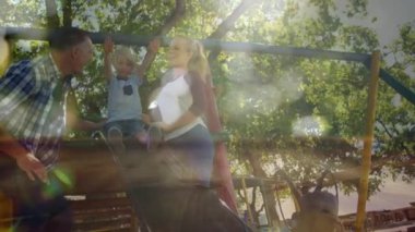 Çocuklarını bokeh ışık efektleriyle oynarken izleyen ebeveynlerin dijital bileşimi.