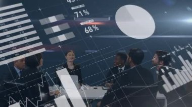 Farklı grafik ve değerlere sahip dijital arayüz ön planda hareket ederken, çeşitli iş adamlarından oluşan bir grubun dijital bileşimi tartışır