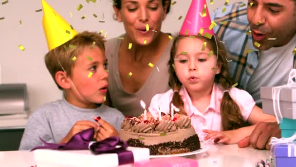 一个白人家庭的数码合成物 庆祝一个小女孩在生日蛋糕上吹蜡烛的生日 而金色的五彩纸屑掉进了银幕 — 图库视频影像