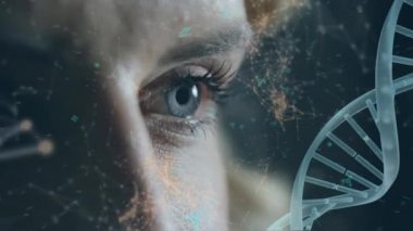 Ekranda hareket eden fütüristik sembollü asimetrik çizgilerle dönen bir DNA çift sarmalının dijital animasyonu. Arka planda mavi gözlü, beyaz bir kadın görünüyor..
