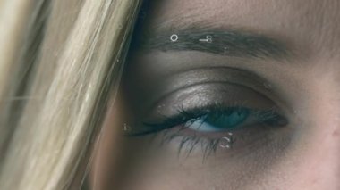 Beyaz dijital saatin dijital animasyonu ekranda hareket eden beyaz bir kadının mavi gözünü açtığını gösteriyor.